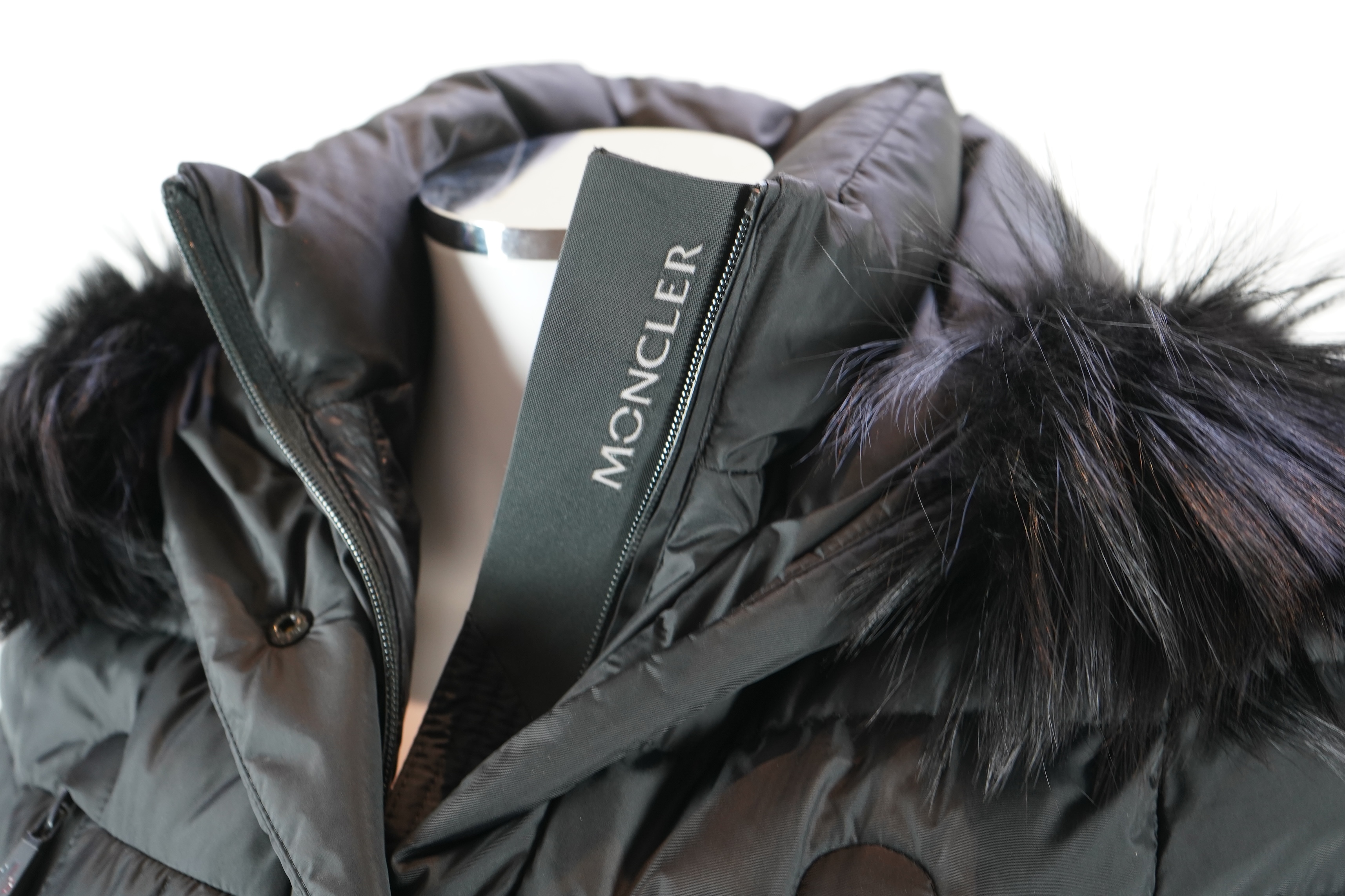 A lady's Moncler Grenoble down black ski jacket with fur trimmed hood and belted waist. UK size 10